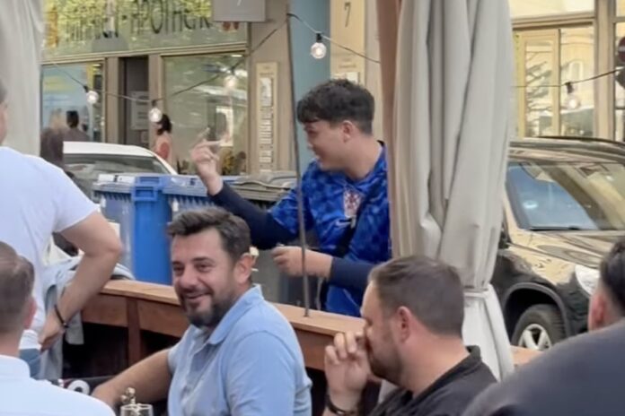Mladić u dresu Hrvatske prolazi pored navijača Srbije u Minhenu